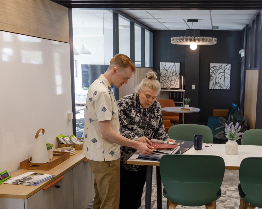 This is a photo of two people reviewing finishes at a commercial furniture showroom