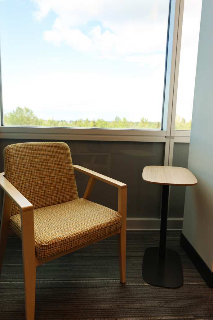 Edward Jones Anchorage Office in SIRI building showing lounge chair with plaid finish and laptop side table near a window