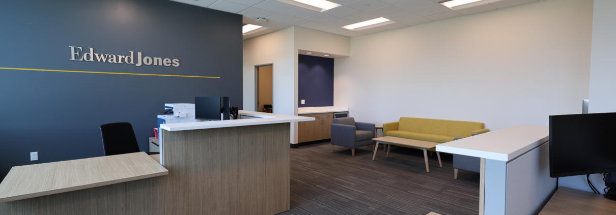 Edward Jones Anchorage Office in SIRI building showing reception desk, Edward Jones logo on the wall, reception lounge or waiting area with coffee table and lounge seating,