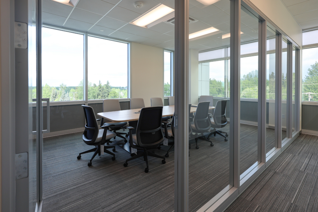 Edward Jones Anchorage office in SIRI building conference room with conference table that has integrated power / outlets, storage credenza, and 10 task chairs with modular glass wall store fronts and swing door