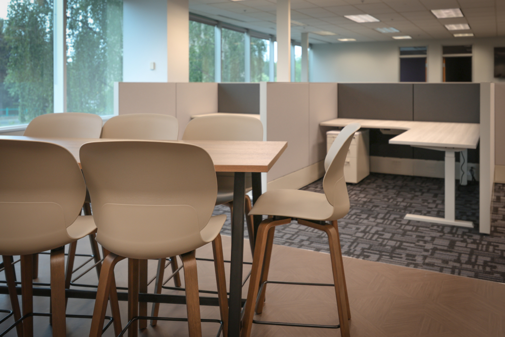 asrc-collaboration-space-open-office-workstations Collaborative meeting area with Haworth Maari seating connected to an open office featuring Haworth Compose workstations at Arctic Slope Regional Corporation, supporting teamwork and focused individual work
