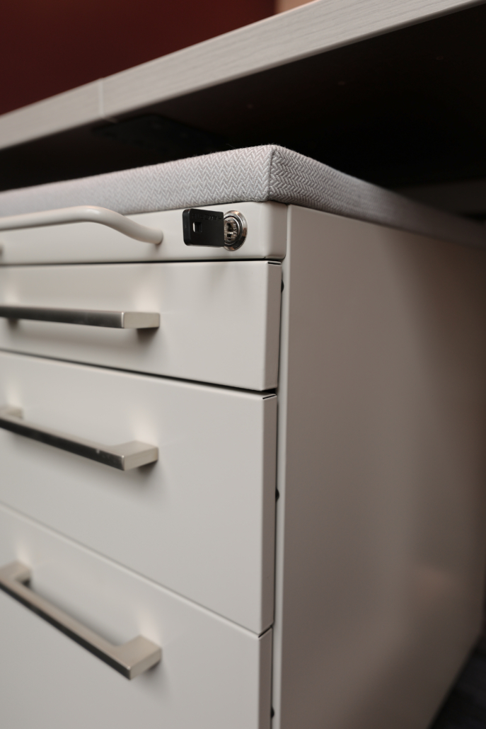 asrc-locking-mobile-pedestal-office-storage Locking mobile pedestal storage installed beneath a Haworth Compose workstation at Arctic Slope Regional Corporation, providing secure personal storage and workplace organization within the IT office.