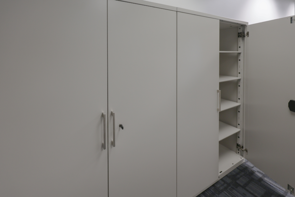 asrc-locking-office-storage-cabinets Locking office storage cabinets installed at Arctic Slope Regional Corporation with adjustable shelving for securely organizing files, office supplies, equipment, and operational materials within the IT workspace.